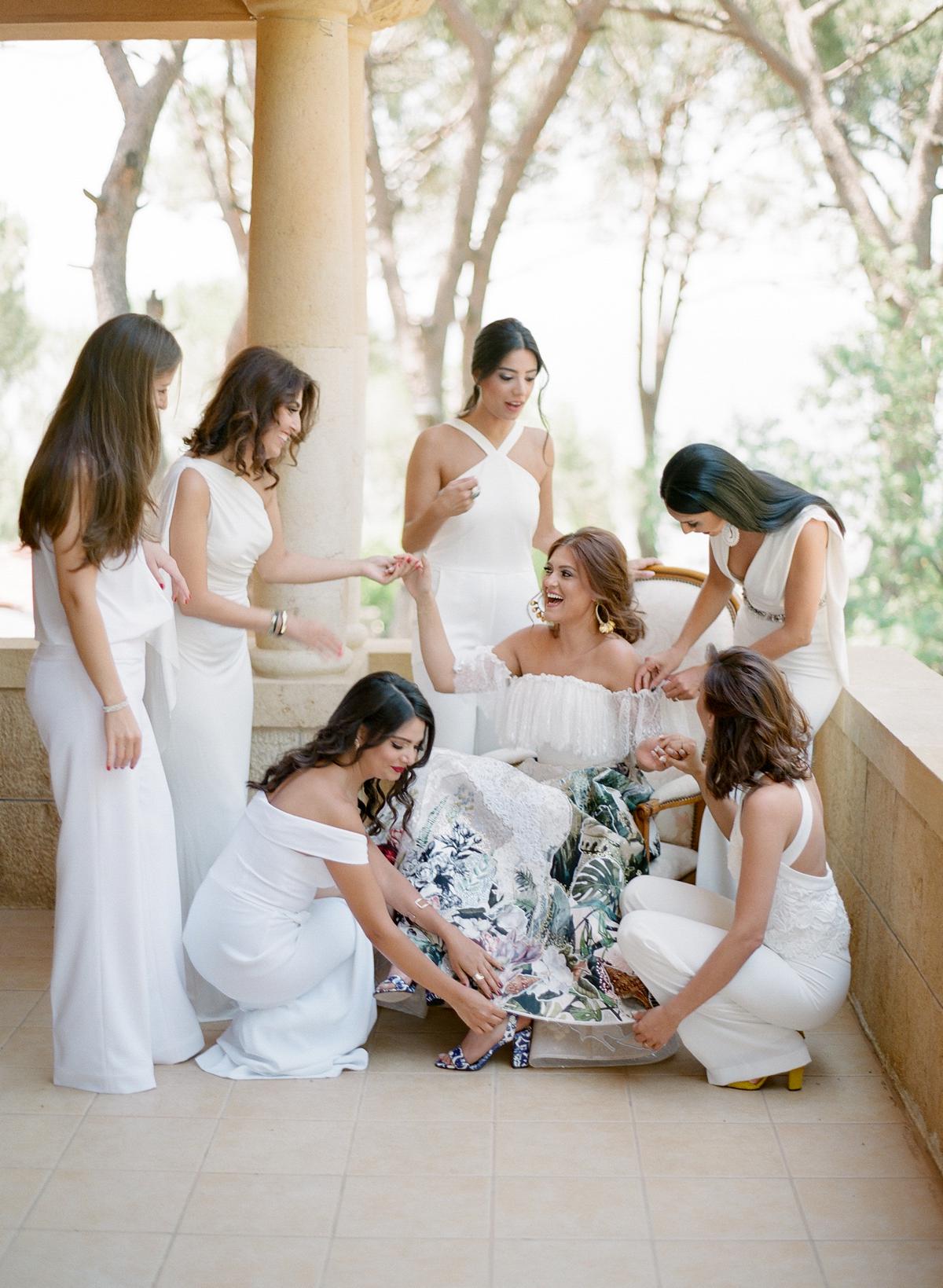 Bride wearing an amazing colorful Hussein Bazaza wedding dress with bridesmaids