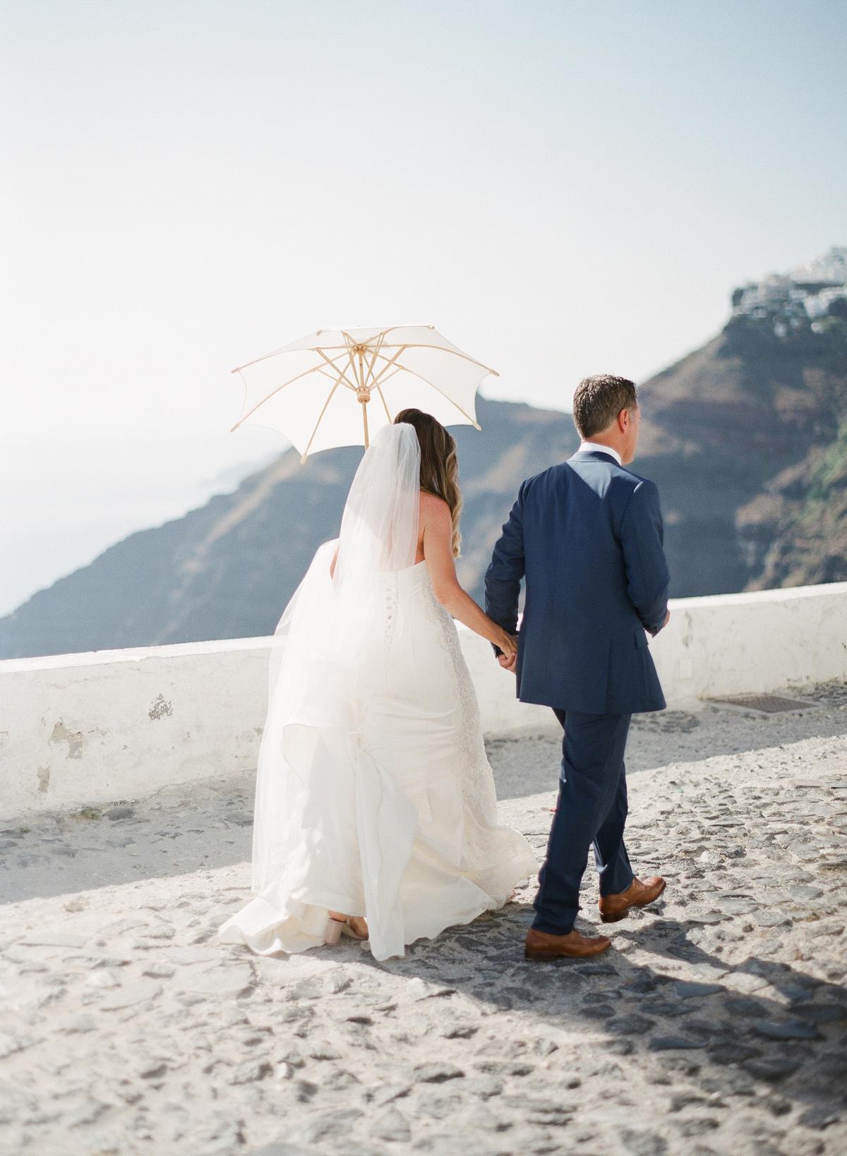 bride and groom walking to church in Santorini