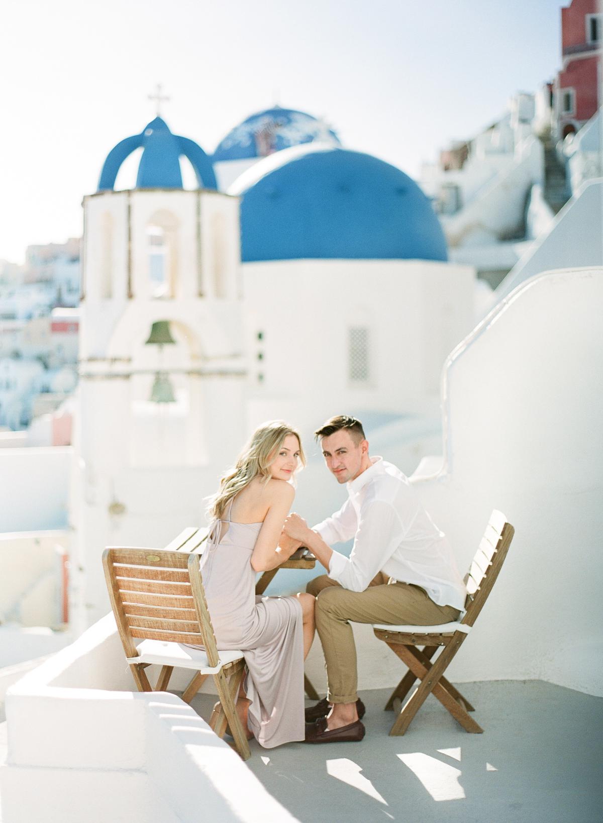 couple during engagement session at the blue domes in oia santorini