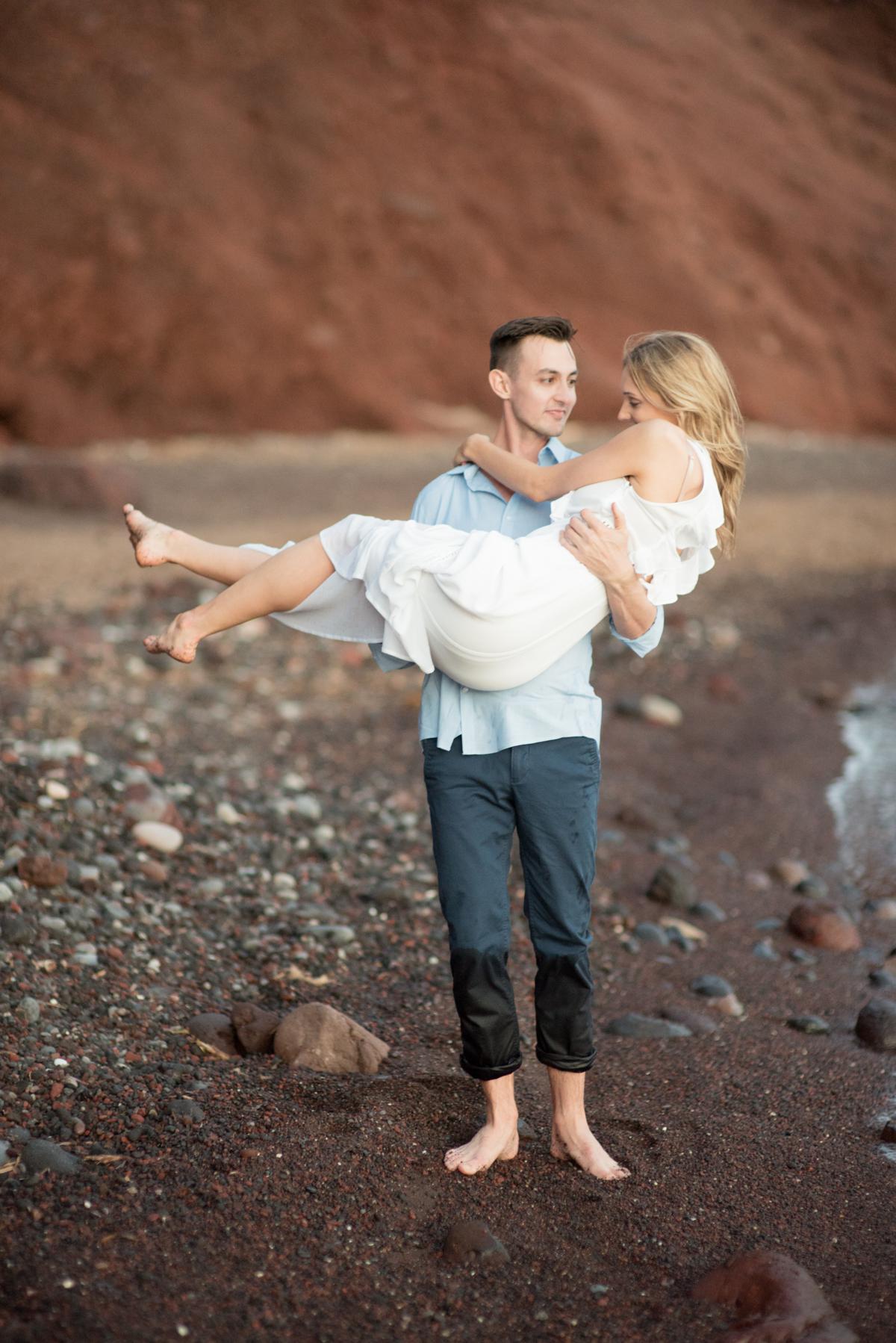 couple in love at beach during engagement session in santorini