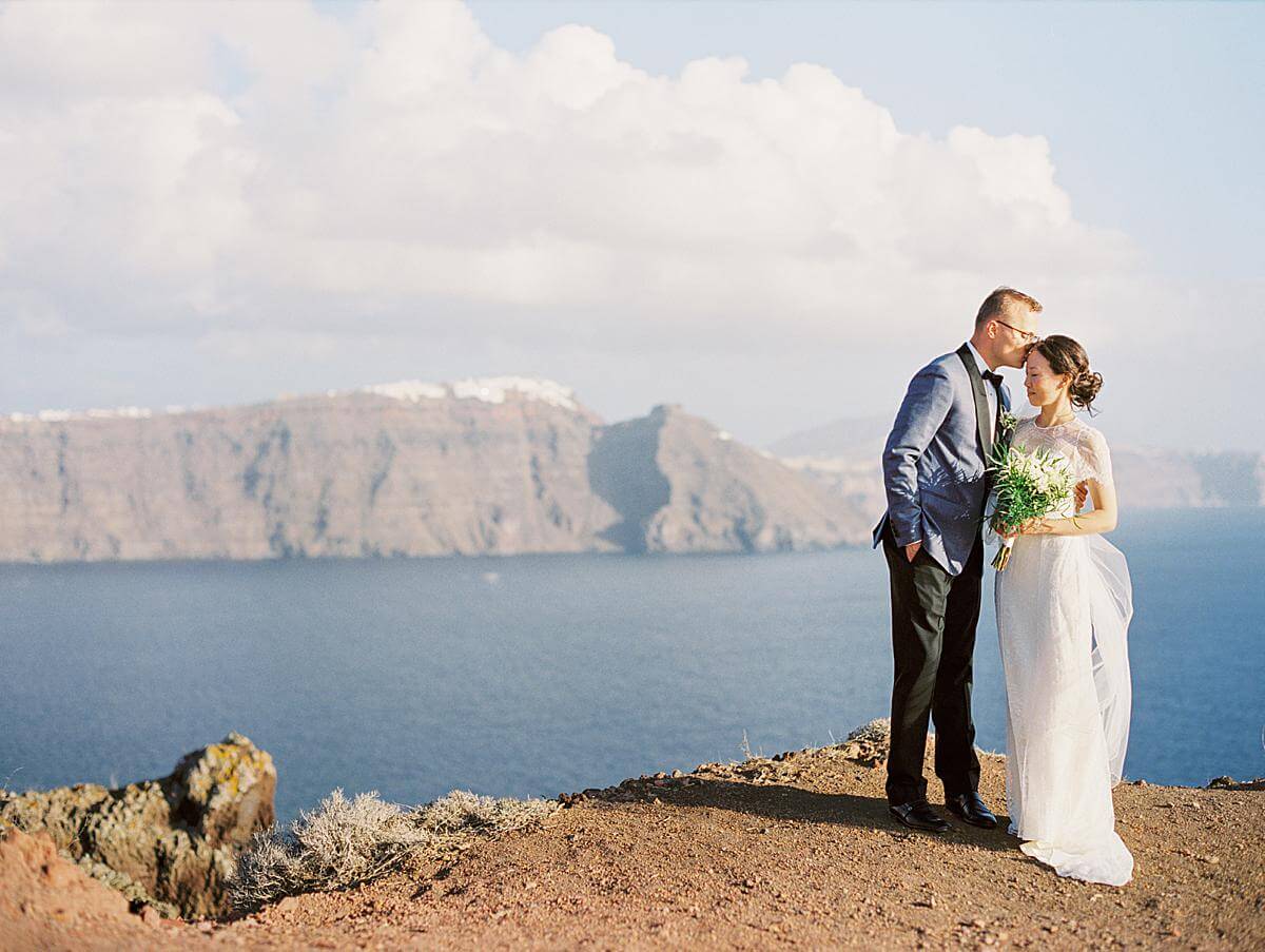 bride and groom portrait at a santorini wedding at a cliff at santorini