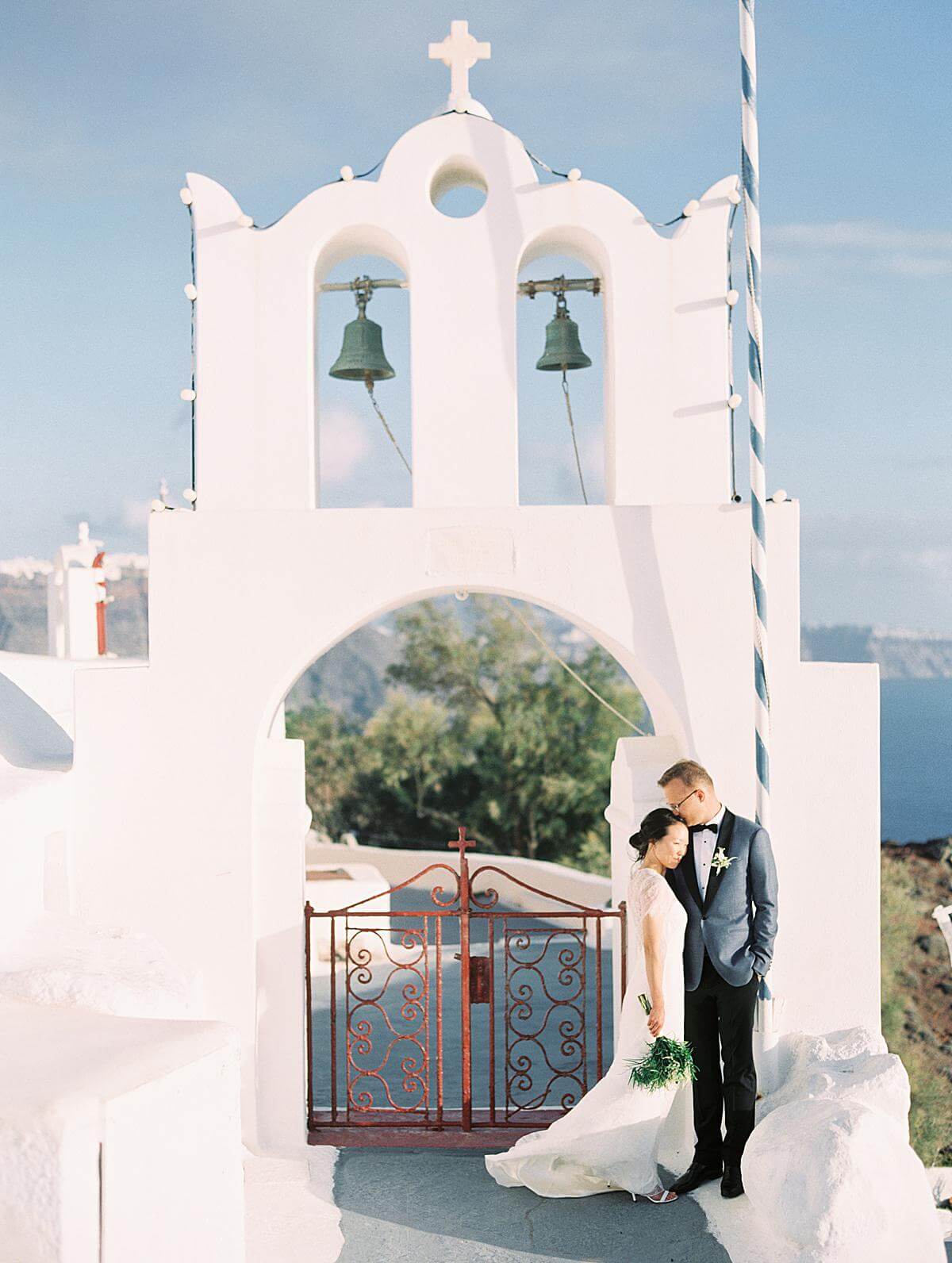 bride and groom at a santorini wedding in front of a church