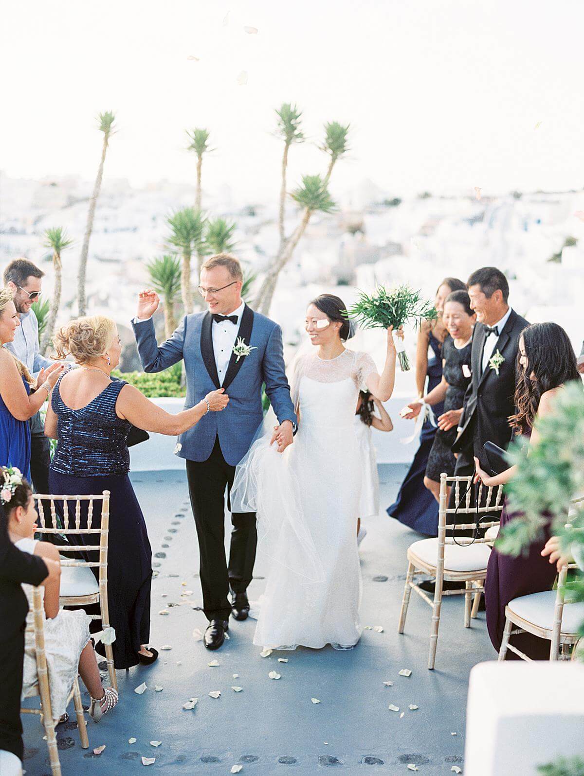 bride and groom exiting their wedding ceremony at Ikies hotel venue in Santorini