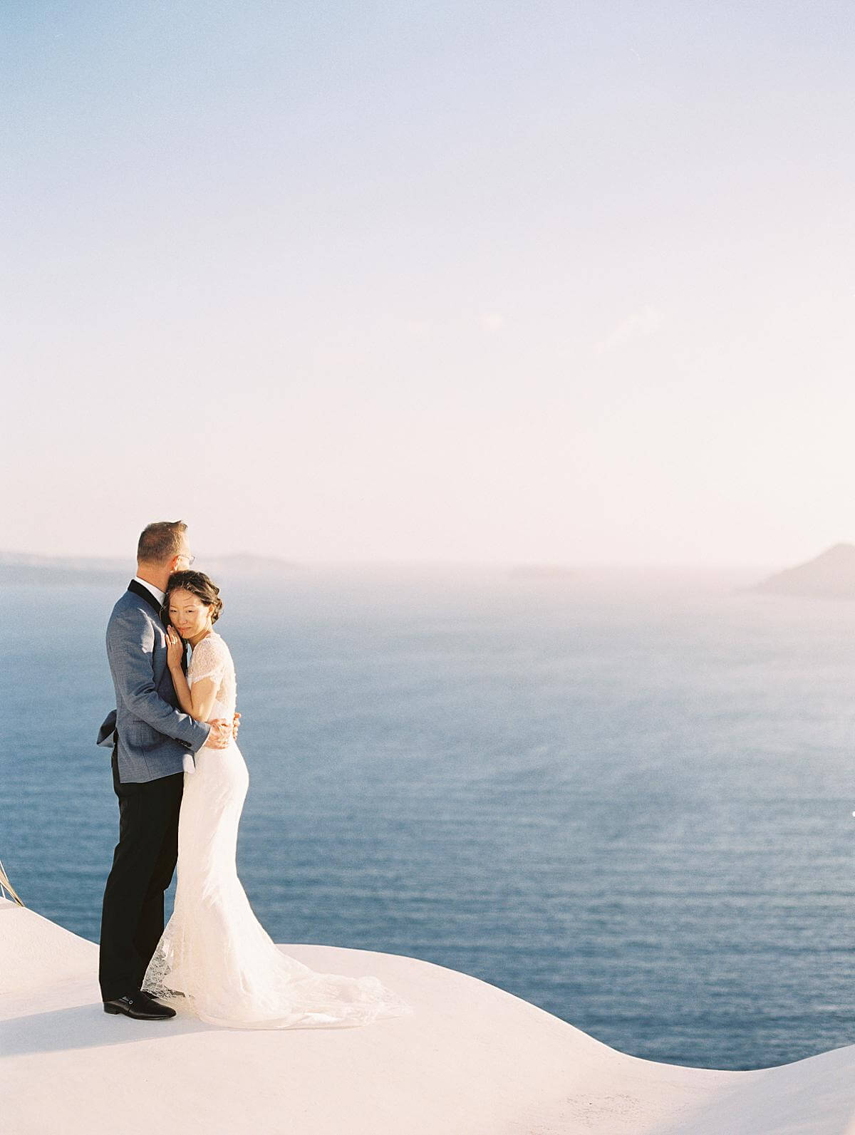 bride and groom portrait on a church rooftop at Ikies hotel Santorini
