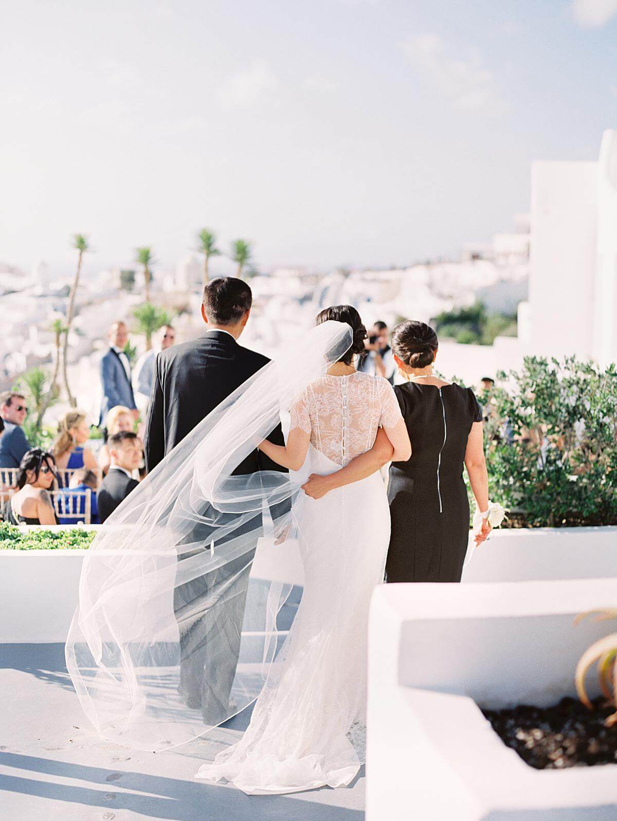 bride escorted by father entering her wedding ceremony at Ikies hotel Santorini