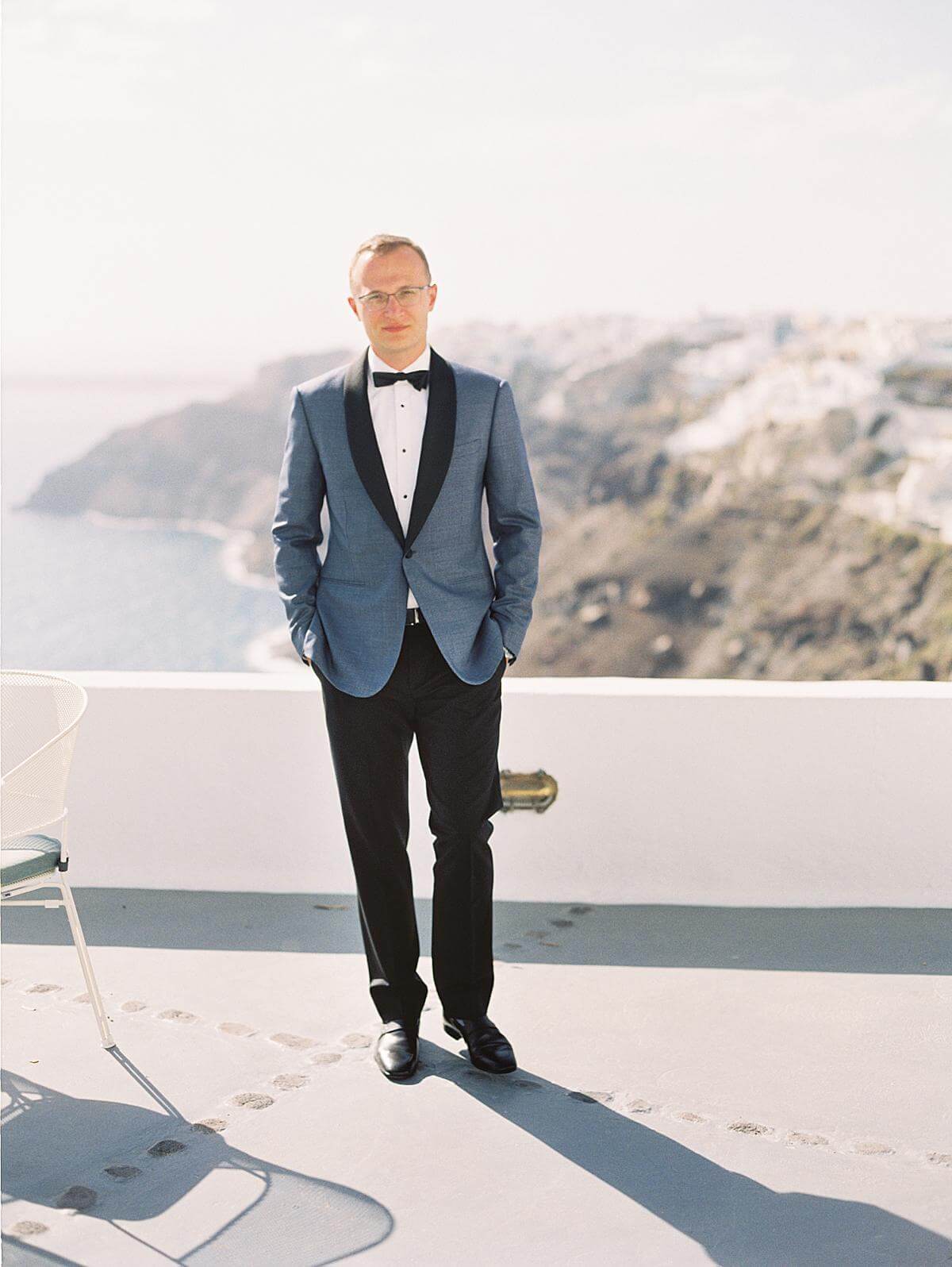 groom portrait in blue suit at Ikies Hotel venue in santorini