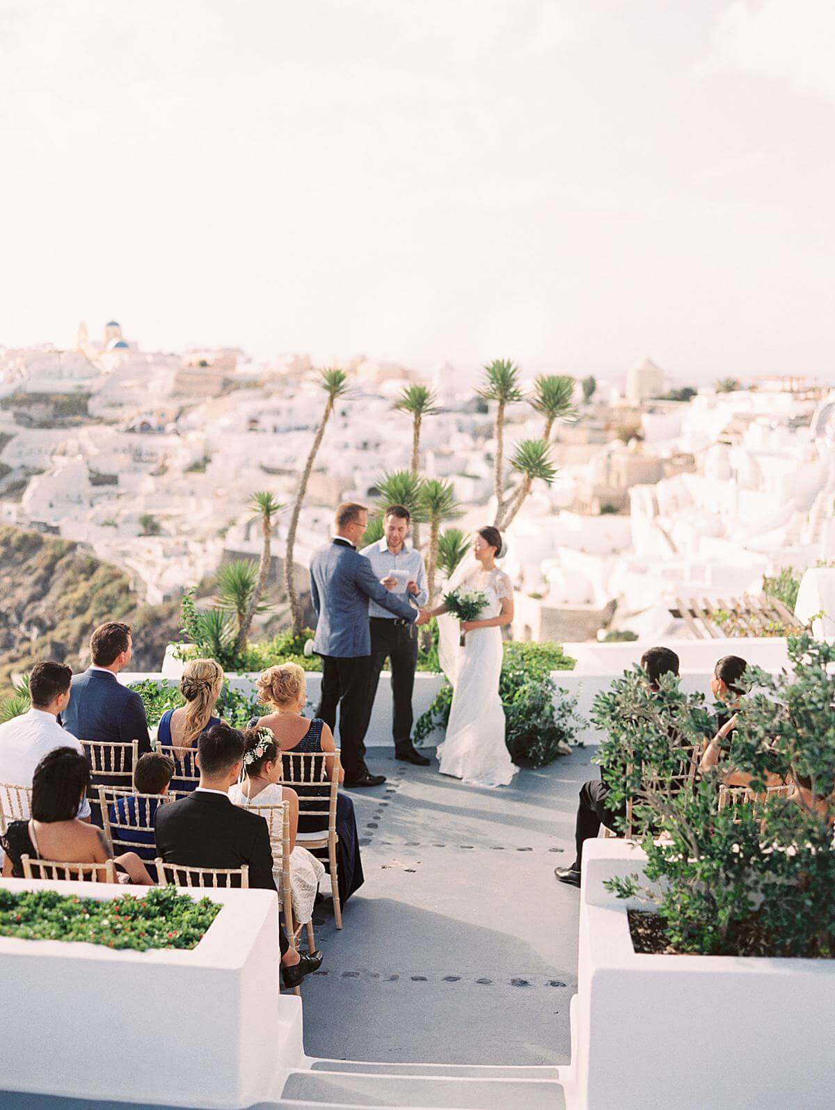 bride and groom exchanging vows during wedding ceremony at Ikies Santorini