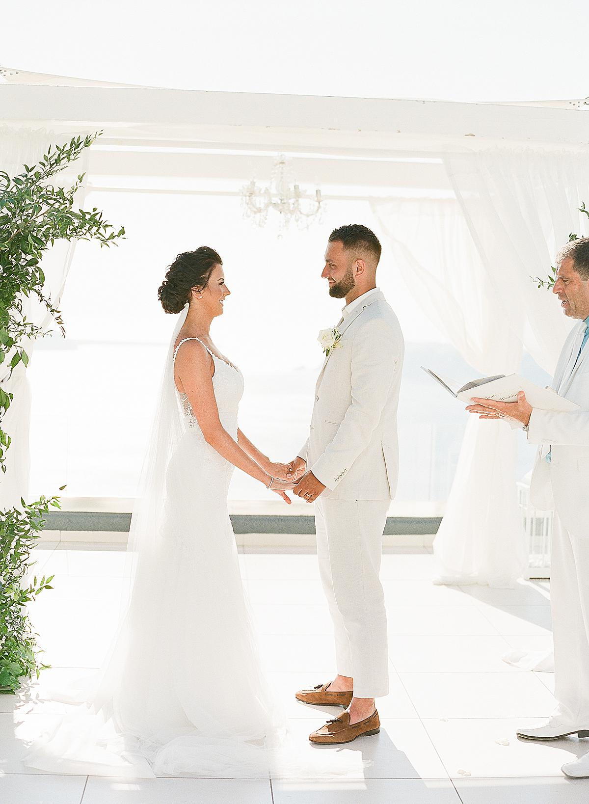 bride and groom exchanging vows at santorini wedding