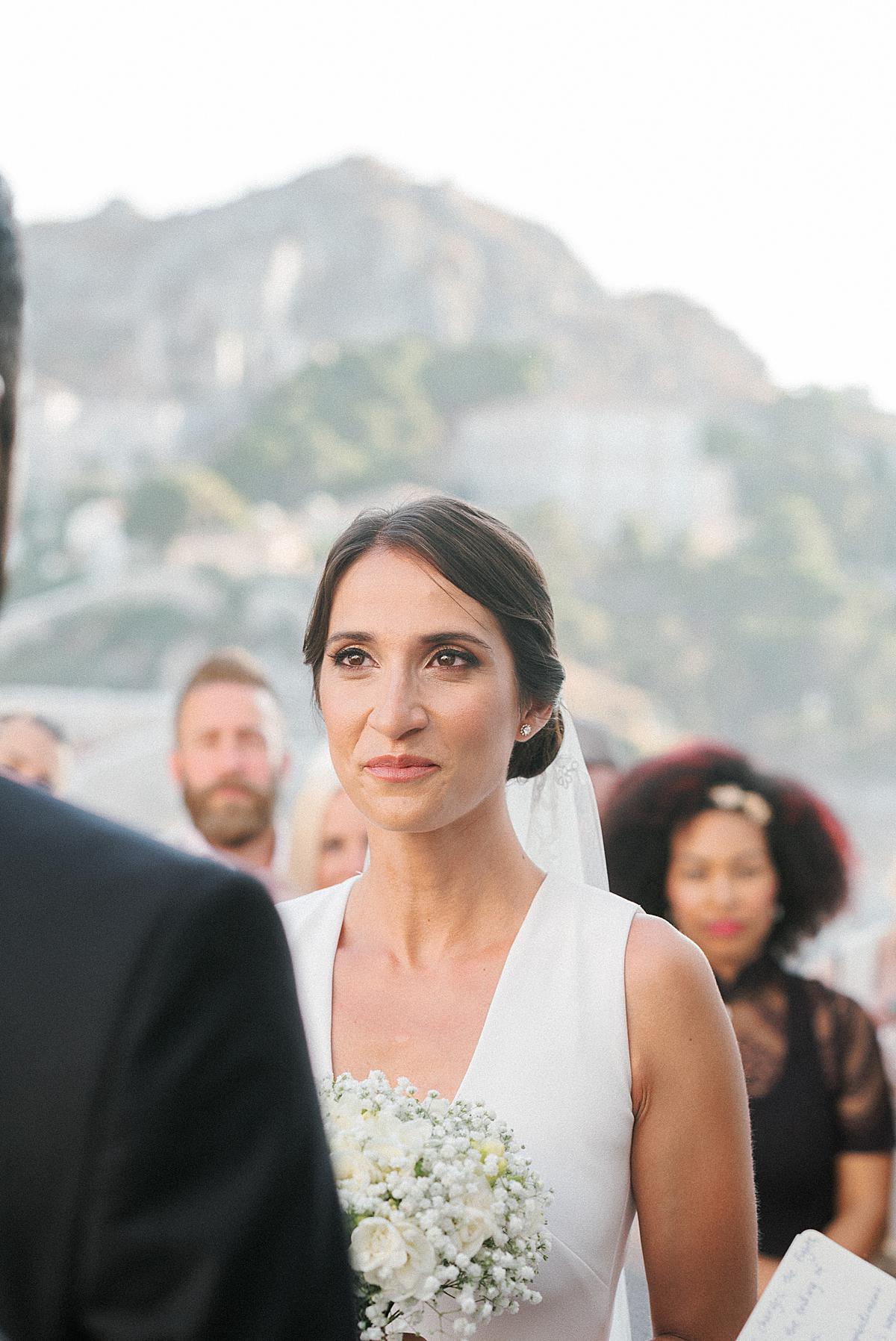 bride getting emotional looking at her husband at wedding on hydra island