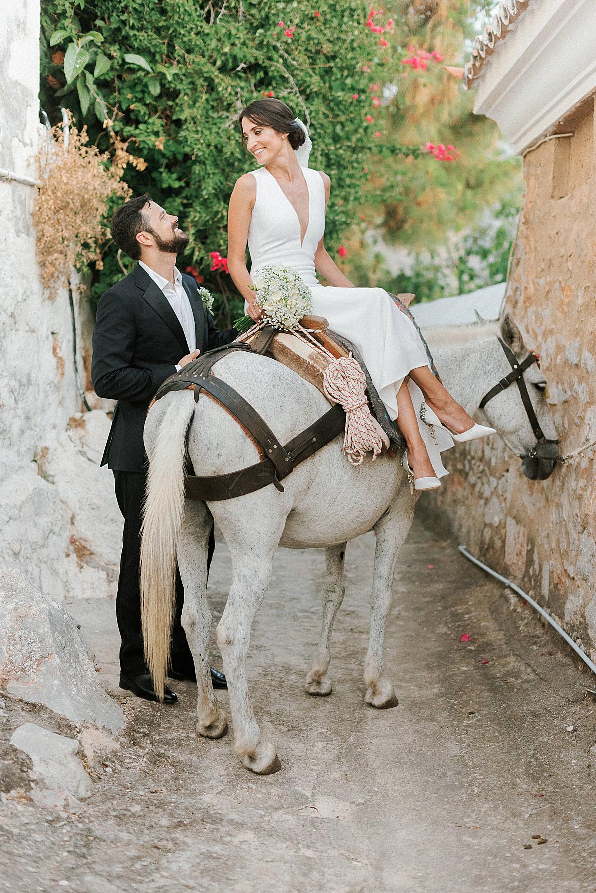 groom and bride on donkey at hydra wedding
