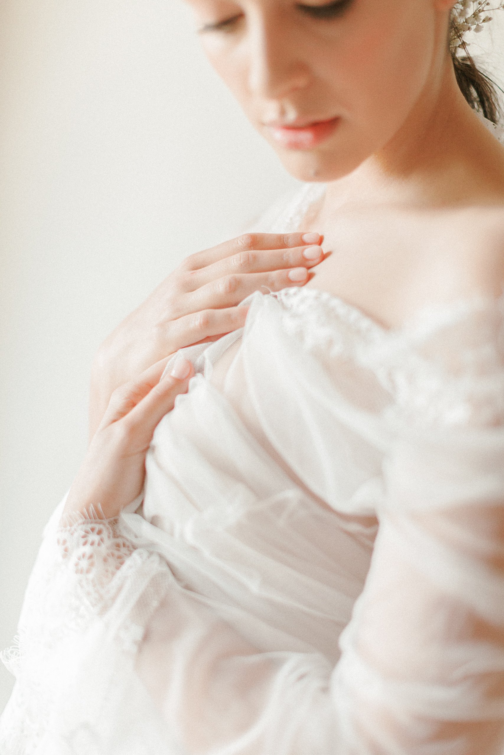 Close up of bride wrapped in tulle for a fine art bridal boudoir session
