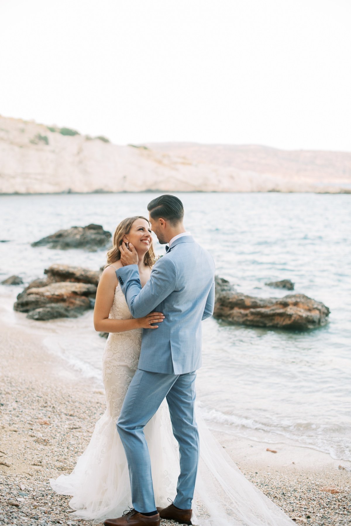 bride and groom kissing on the beach for a destination wedding in the athenian riviera - les anagnou photography